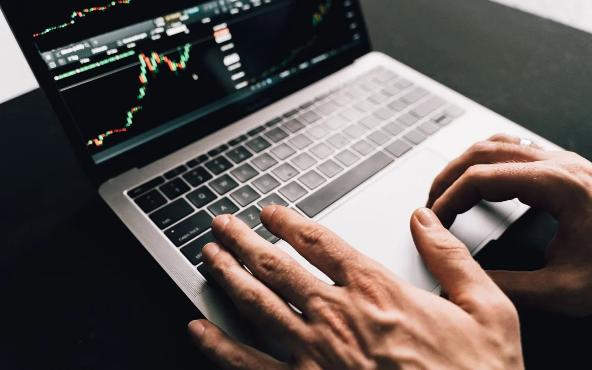 Persoană care folosește un laptop cu grafice financiare