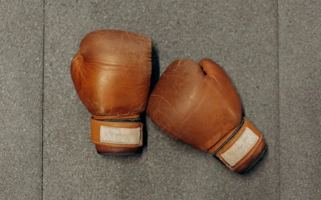 Pereche de mănuși maro de box pe o suprafață gri