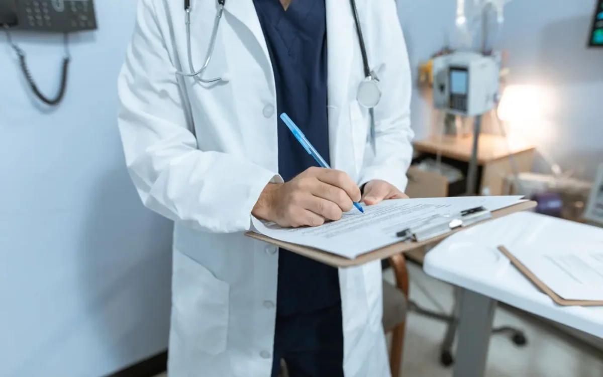 Medic care completează documente medicale
