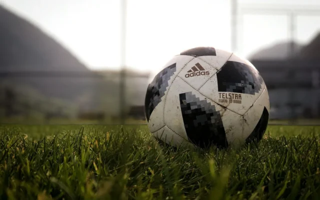Minge de fotbal albă și neagră pe gazon, la amurg