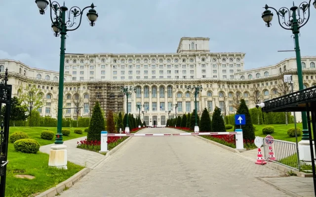 Fațada și intrarea Palatului Parlamentului din București, între felinare